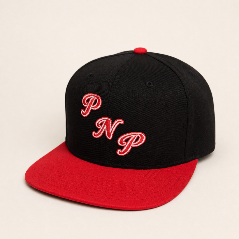 PNP Snapback in black with red brim — front three-quarter view with red and white PNP embroidery